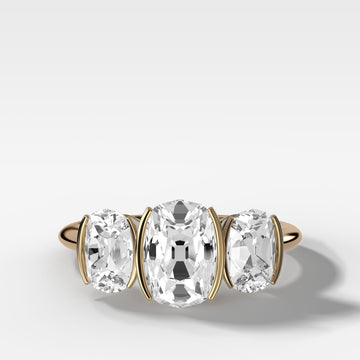 elongated-old-mine-cut-three-stone-ring-half-bezel